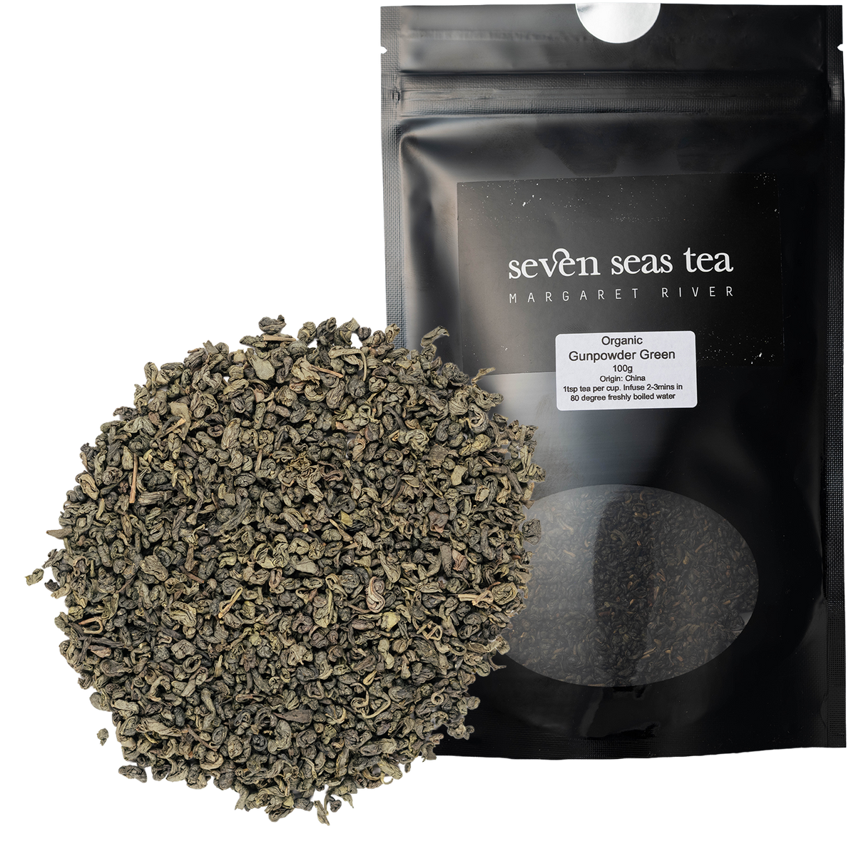 Loose leaf Organic Gunpowder Green piled beside its black Seven Seas Tea pouch