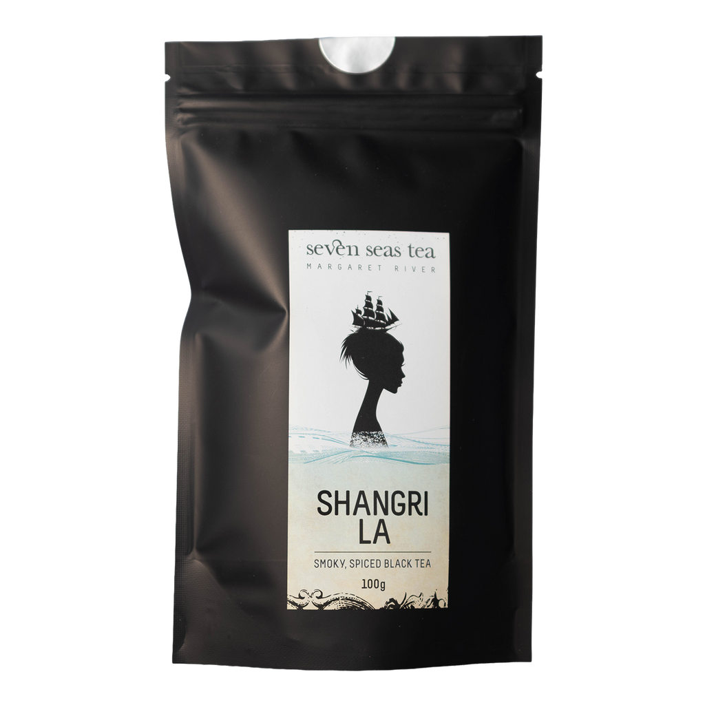 Black pouch of Shangri La Smoky Spiced Black Tea with a window showing the leaf